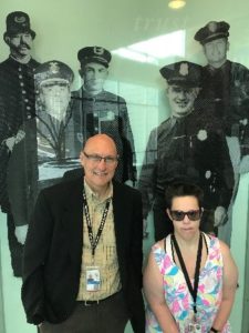 Becky and Sergeant Tower smile for a photo in the police department