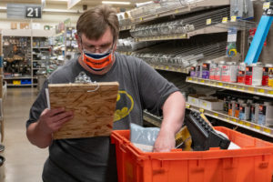 photo of Jeff reading his clipboard and reaching into his cart to grab an item